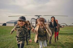 lachend preteen meisjes rennen Aan vliegend veld- foto