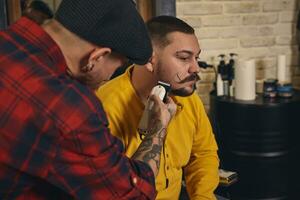 cliënt gedurende baard scheren in kapper winkel foto