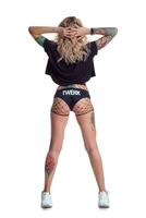 mooi blond danser vrouw in buit shorts en visnet staan achteruit geïsoleerd Aan wit achtergrond foto