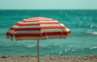 ai gegenereerd een strand tafereel met een rood en wit gestreept paraplu foto