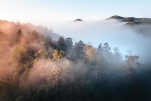 de zon komt op in de mist en de bergen in de ochtend foto
