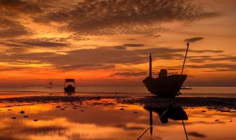 silhouet visserij houten boot met zonsondergang hemel lage verlichting.