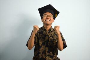 expressief van volwassen Indonesië mannetje slijtage batik, toga kop of diploma uitreiking hoed en bril geïsoleerd Aan wit achtergrond, uitdrukkingen van portret diploma uitreiking foto