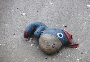 gooi afval oude stoffen pop op het strand weg. foto