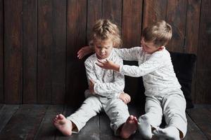 twee kinderen, broer en zus in pyjama spelen samen