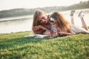 moeder met een kind leest een boek op het gras