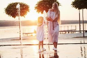 moeder met baby bij de fontein bij zonsondergang foto
