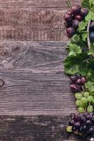 houten achtergrond met druiven en wijnstokken foto