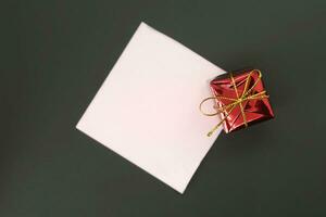 geschenk doos en blanco papier Aan de zwart achtergrond, top visie foto