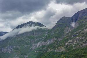 mist mist wolken watervallen op de berg noorse landschap jotunheimen noorwegen. foto