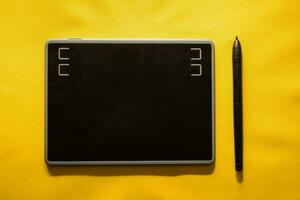 elektronisch tekening pen tablet en stylus geïsoleerd geel foto