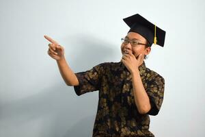 expressief van volwassen Indonesië mannetje slijtage batik, toga kop of diploma uitreiking hoed en bril geïsoleerd Aan wit achtergrond, uitdrukkingen van portret diploma uitreiking foto