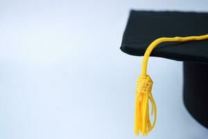dichtbij omhoog zwart diploma uitreiking hoed en geel kwast geïsoleerd Aan wit achtergrond foto