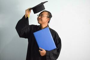 expressief van volwassen Indonesië mannetje slijtage diploma uitreiking gewaad, hoed en bril, Aziatisch mannetje diploma uitreiking brengen blanco blauw certificaat geïsoleerd Aan wit achtergrond, uitdrukkingen van portret diploma uitreiking foto