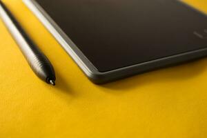 elektronisch tekening pen tablet en stylus dichtbij omhoog geïsoleerd geel foto
