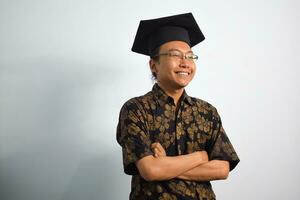 expressief van volwassen Indonesië mannetje slijtage batik, toga kop of diploma uitreiking hoed en bril geïsoleerd Aan wit achtergrond, uitdrukkingen van portret diploma uitreiking foto