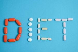 eetpatroon woord van kleurrijk geneeskunde pillen geïsoleerd Aan blauw achtergrond, supplement, vitamine, kleurrijk foto
