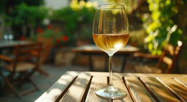 ai gegenereerd een glas van wit wijn is houdende Aan een tafel buitenshuis foto