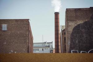 rook afkomstig van een industriële bakstenen schoorsteen in een oud fabrieksgebouw foto