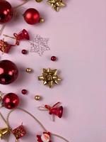 kerstversiering, geschenkdooslinten, gouden ballen, sneeuwvlokken, rode ballen op roze achtergrond foto