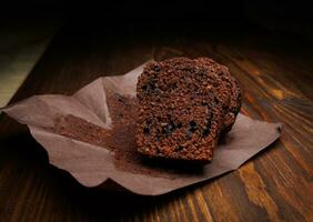 chocola koekje besnoeiing in voor de helft Aan een donker achtergrond. muffin met chocola chips Aan donker papier. foto