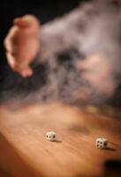een hand- het werpen Dobbelsteen op een backgammon bord. foto