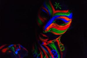 vrouw met make-up kunst van gloeiend uv fluorescerend poeder foto