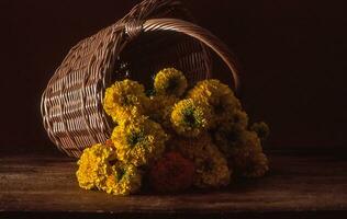 een mand van geel bloemen zittend Aan een tafel foto