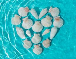 creatief tafereel van liefde hart symbool gemaakt met zee schelpen in water Aan helder blauw achtergrond. minimaal zomer concept. origineel achtergrond beeld met een Speel van licht en schaduw. zomertijd liefde idee. foto