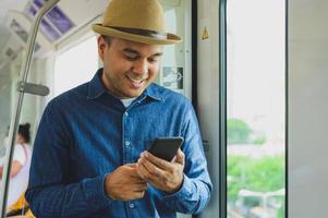 aziatische man met smartphone in sky train foto