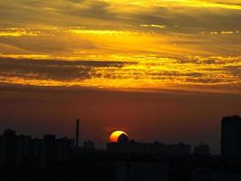 zon stijgt boven de skyline van de stad van kyiv, oekraïne foto