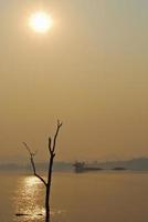 prachtig uitzicht schaduwen licht boot met lange staart zonsopgang in dam srinakarin nationaal park kanchanaburi, thailand foto