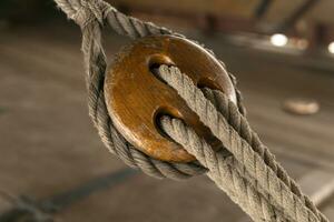 detail van de tuigage van een oud het zeilen schip, een houten verdrievoudigen dood oog blok met draagriem foto