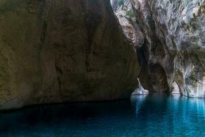 Doorzichtig blauw water in een diep Ravijn met puur rots muren foto