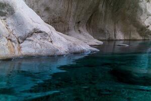 schoon blauw rivier- met rotsachtig banken Bij de bodem van een diep Ravijn foto