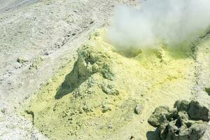 geel ijshoorntje van gekristalliseerd zwavel in de omgeving van een roken solfatara Aan de helling van een vulkaan foto