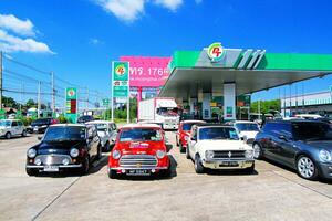 Nakhon Ratchasima, thailand-december 6, 2023 oud kleurrijk Austin mini kuiper auto parkeren in gas- station en Doorzichtig blauw lucht met kopiëren ruimte. vervoer, klassiek of wijnoogst auto en voertuig concept. foto