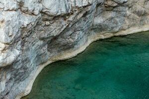 stenen en water, kust van een berg meer met blauw water tussen de rotsen foto