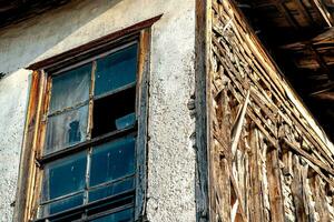 oud verlaten houten huis met gebroken glas, fragment foto