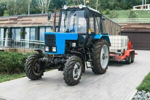 op wielen trekker met irrigatie tanks Aan een aanhangwagen voor onderhoud van stedelijk groen ruimten foto