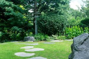 Japans tuin landschap met steen lantaarn onder pijnboom boom foto