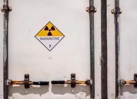 stralingswaarschuwingsbord op het transportlabel voor gevaarlijke goederen klasse 7 bij de container van transportvrachtwagen foto