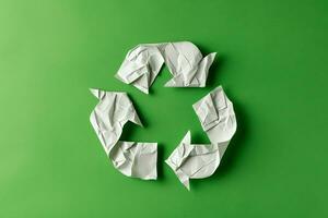 ai gegenereerd recycle symbool gemaakt van wit papier Aan groen achtergrond foto