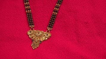 mangalsutra of gouden ketting om te dragen door een getrouwde hindoe vrouwen, gearrangeerd met mooie achtergrond. Indiase traditionele sieraden. foto