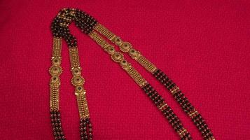 mangalsutra of gouden ketting om te dragen door een getrouwde hindoe vrouwen, gearrangeerd met mooie achtergrond. Indiase traditionele sieraden. foto