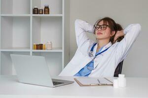 benadrukt jong vrouw dokter op zoek Bij laptop, werk verwant chaos, bezorgd over vergissing Bij werk de gestrest, ongelukkig medisch professioneel is moe van oplossen computer problemen Bij werk. foto