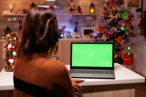 jong volwassen aan het kijken laptop apparaat met groen scherm technologie voor mockup sjabloon app. Kaukasisch vrouw gebruik makend van notitieboekje voor digitaal chroma sleutel geïsoleerd Scherm Aan virtueel apparaatje foto