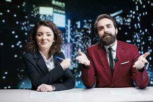 nieuwslezers team debatteren leven topics Aan TV kanaal, omroep nacht tonen wereldwijd en bespreken over laatste nieuws of interessant evenementen. Mens en vrouw collega's werken in media industrie. foto