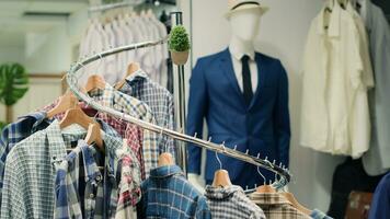 pannen schot van elegant selectie van overhemden Aan hangers in hoog einde mode winkel presentatie van trendy, elegant kledingstukken van hun nieuw verzameling. dichtbij omhoog Aan mannen overhemden in winkelcentrum kleding op te slaan foto