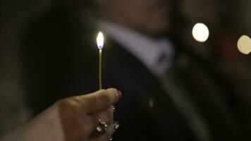 verlichting een kaars met een bij elkaar passen naar krijgen een romantisch kaarslicht. verbazingwekkend andles en kandelaars zijn Aan de tafel. blijven lichten met de vredig achtergrond van religieus ceremonie. foto